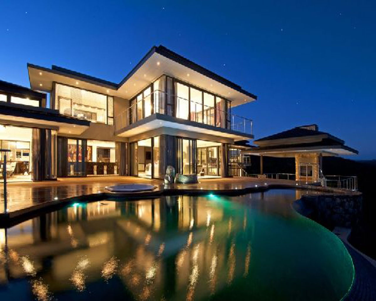 Amazing-architecture-designs-luxury-and-beautiful-house-exteriors-with-curving-swimming-pool-and-deck-with-cool-lighting-view-evening_nivasa_lk